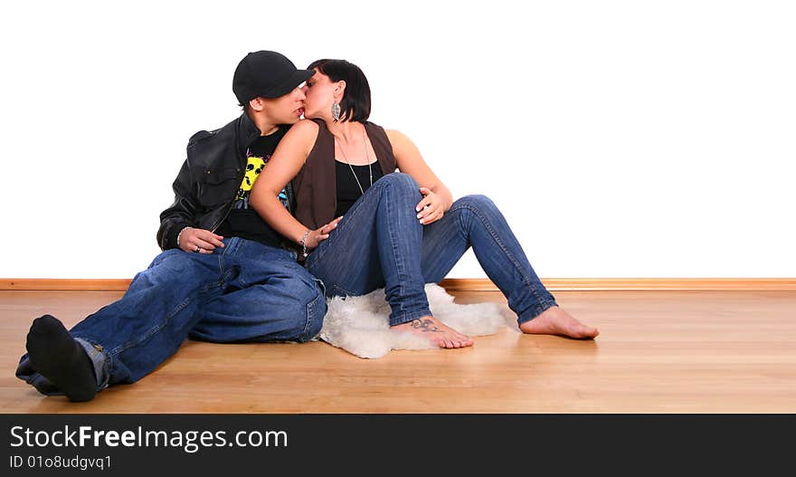 Young stylish couple kissing on the floor of their new home!