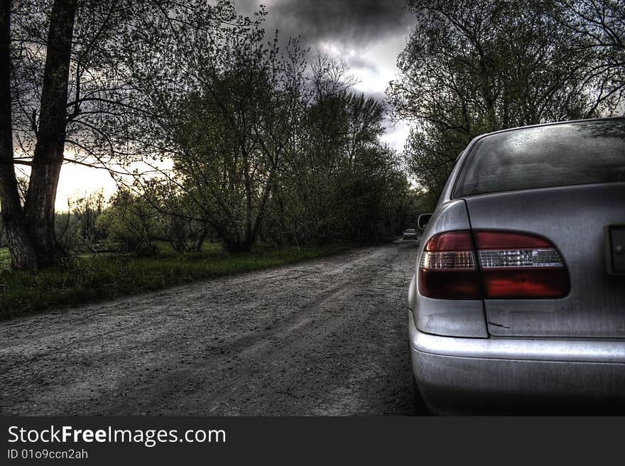 Car on edge of road on a background of a gloomy landscape. HDR image. Car on edge of road on a background of a gloomy landscape. HDR image