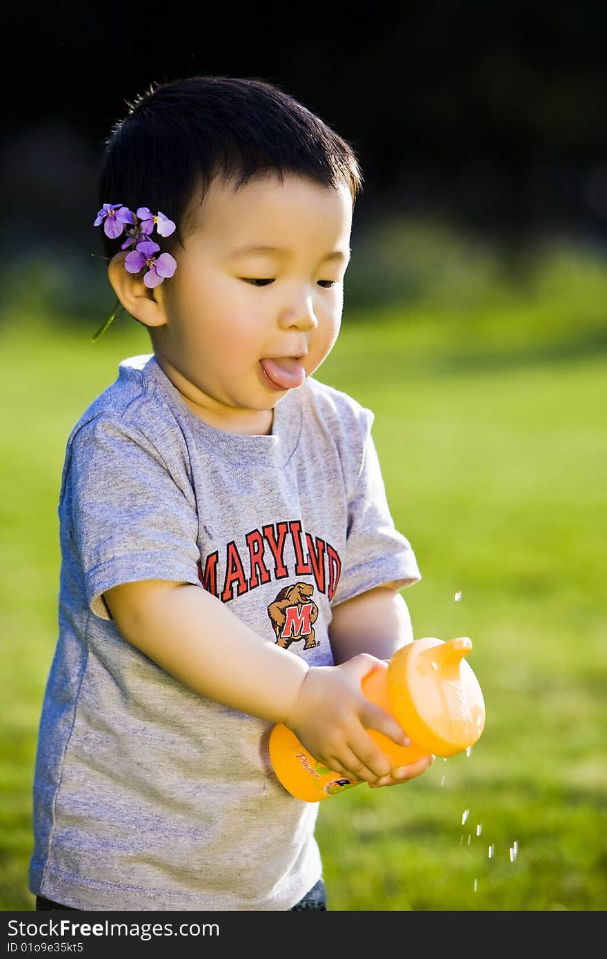 Happy smiling little boy playing water.