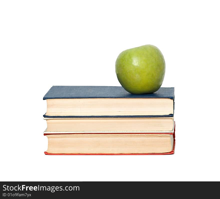 Green apple on pile of books on white background