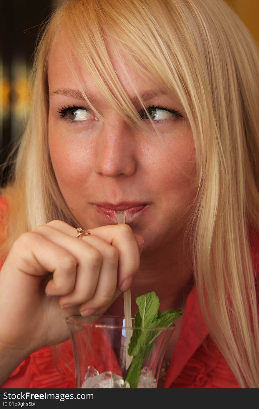 Smiling blond girl drinking closeup