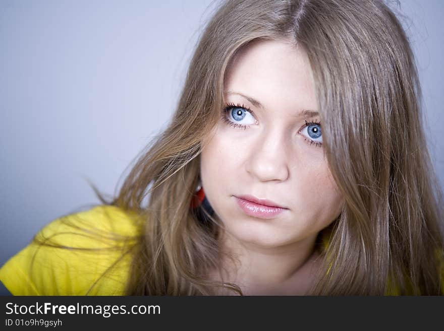 Blonde with blue eyes in a yellow sport shirt and ear-rings. Blonde with blue eyes in a yellow sport shirt and ear-rings