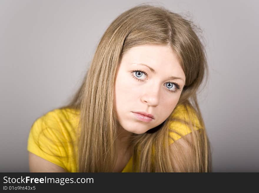 Blonde with blue eyes in a yellow sport shirt and ear-rings. Blonde with blue eyes in a yellow sport shirt and ear-rings