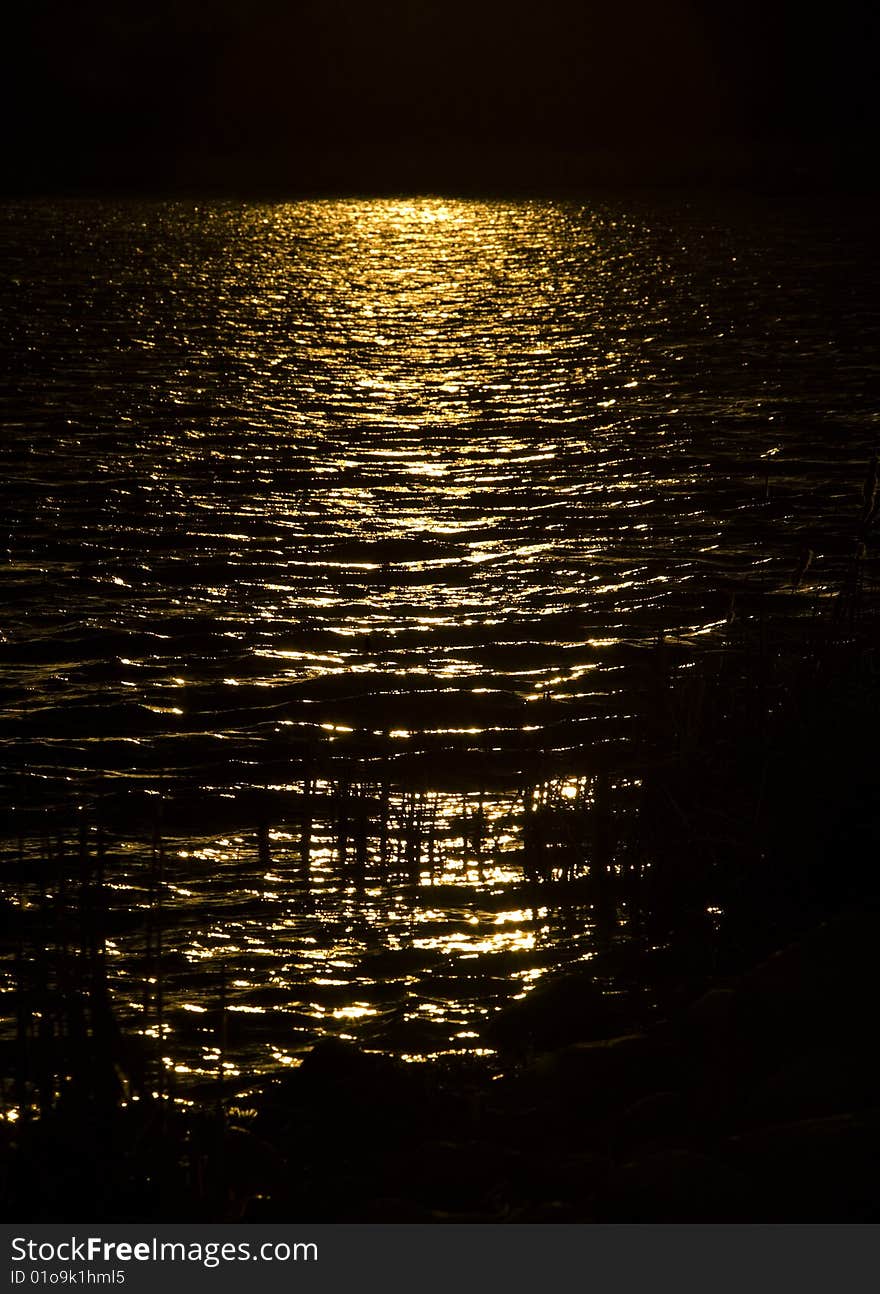 Golden sunbeam on dark lake in the northern Minnesota