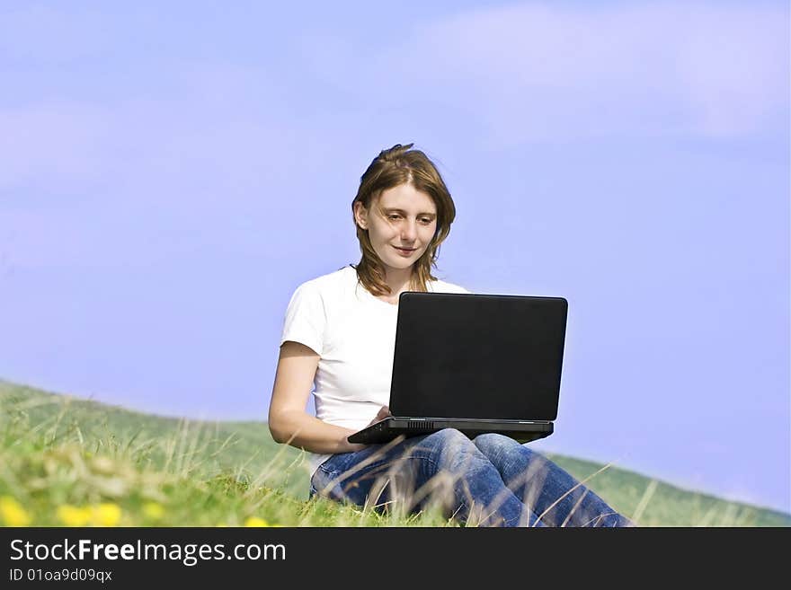 Young blonde girl working on laptop outdoors. Young blonde girl working on laptop outdoors