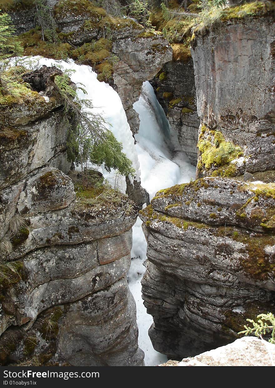 Close proximity of ancient rock shows the narrow channels where in Spring there is still snow in Maligne canyon, Alberta, Canada. Close proximity of ancient rock shows the narrow channels where in Spring there is still snow in Maligne canyon, Alberta, Canada