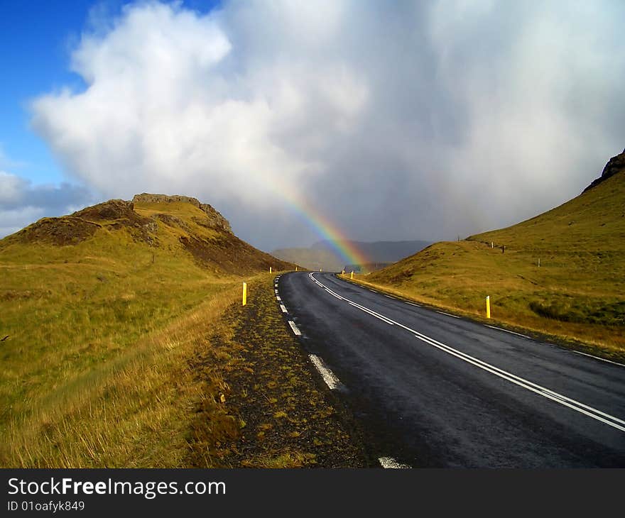 Rainbow over the road. Road around Hvalfjordur, Iceland. Rainbow over the road. Road around Hvalfjordur, Iceland.