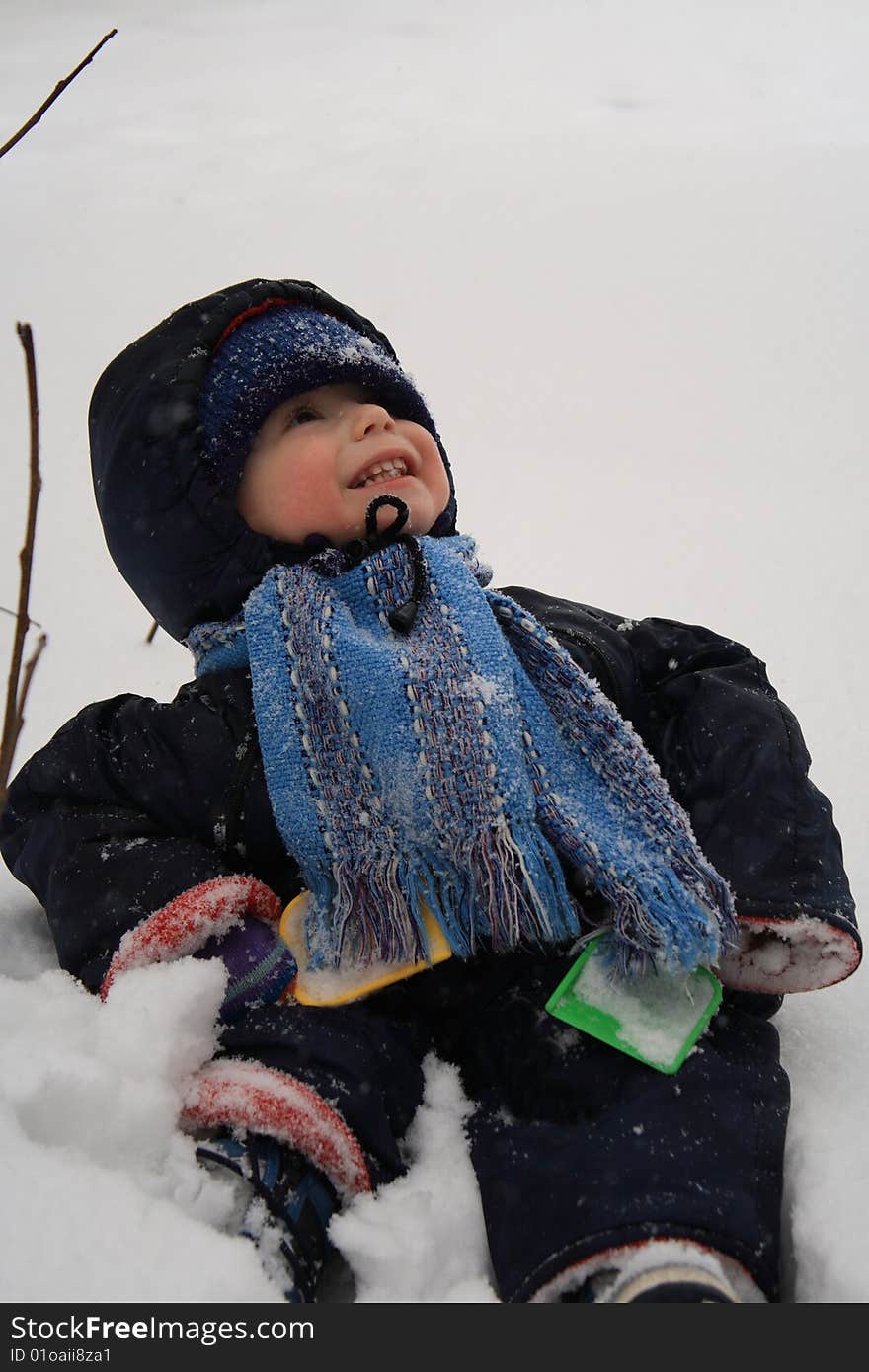 The boy sitting in snow. The boy sitting in snow