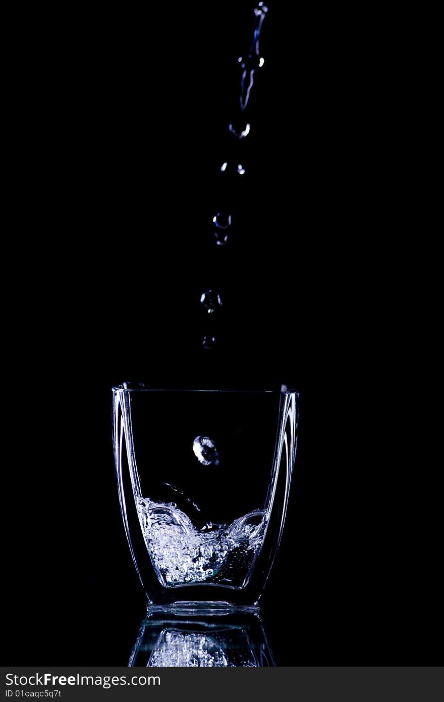 Water drops flow into glass