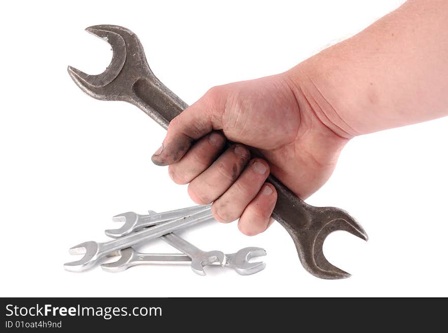 A metallic wrench is in a hand