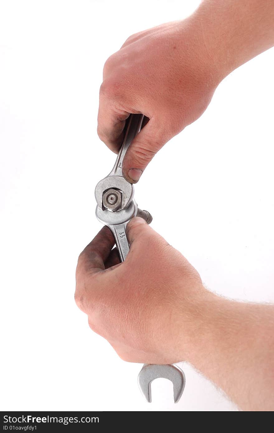 A metallic wrench is in a hand