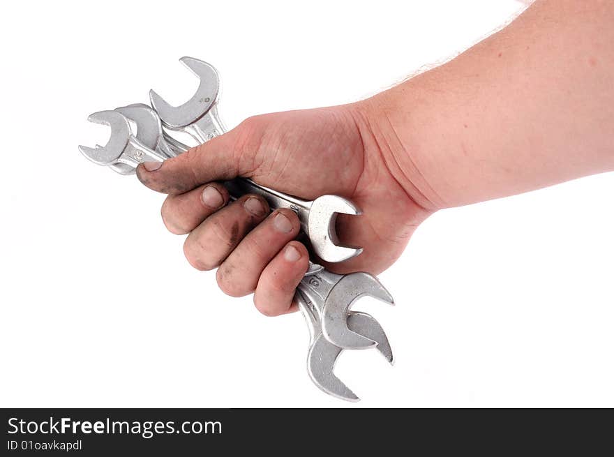 A metallic wrench is in a hand