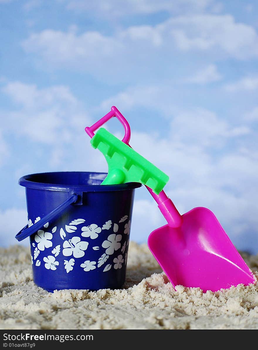 Colorful plastic beach toys in the sand