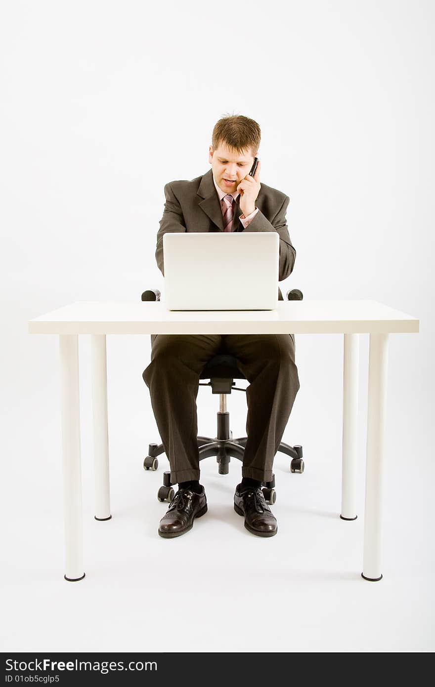 Young businessman working with phone and laptop computer