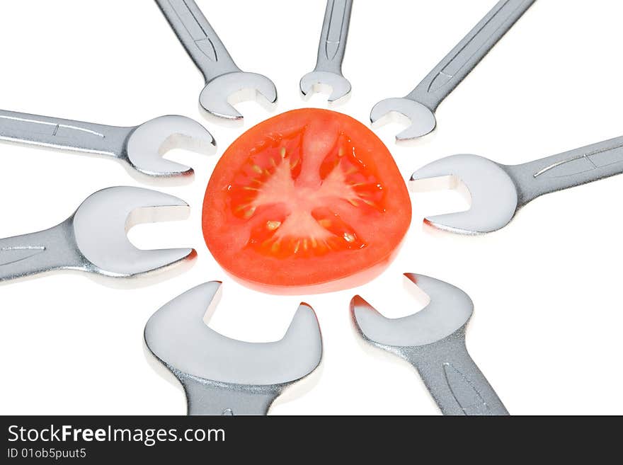 Cut tomato and wrench isolated. Clipping path. Cut tomato and wrench isolated. Clipping path