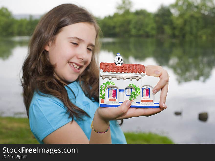 A young girl holding a little house on her hands. A young girl holding a little house on her hands