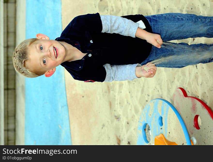 Happy boy playing with sand