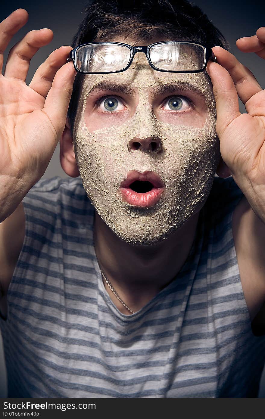 Close-up portrait of funny man with facial mask and glasses