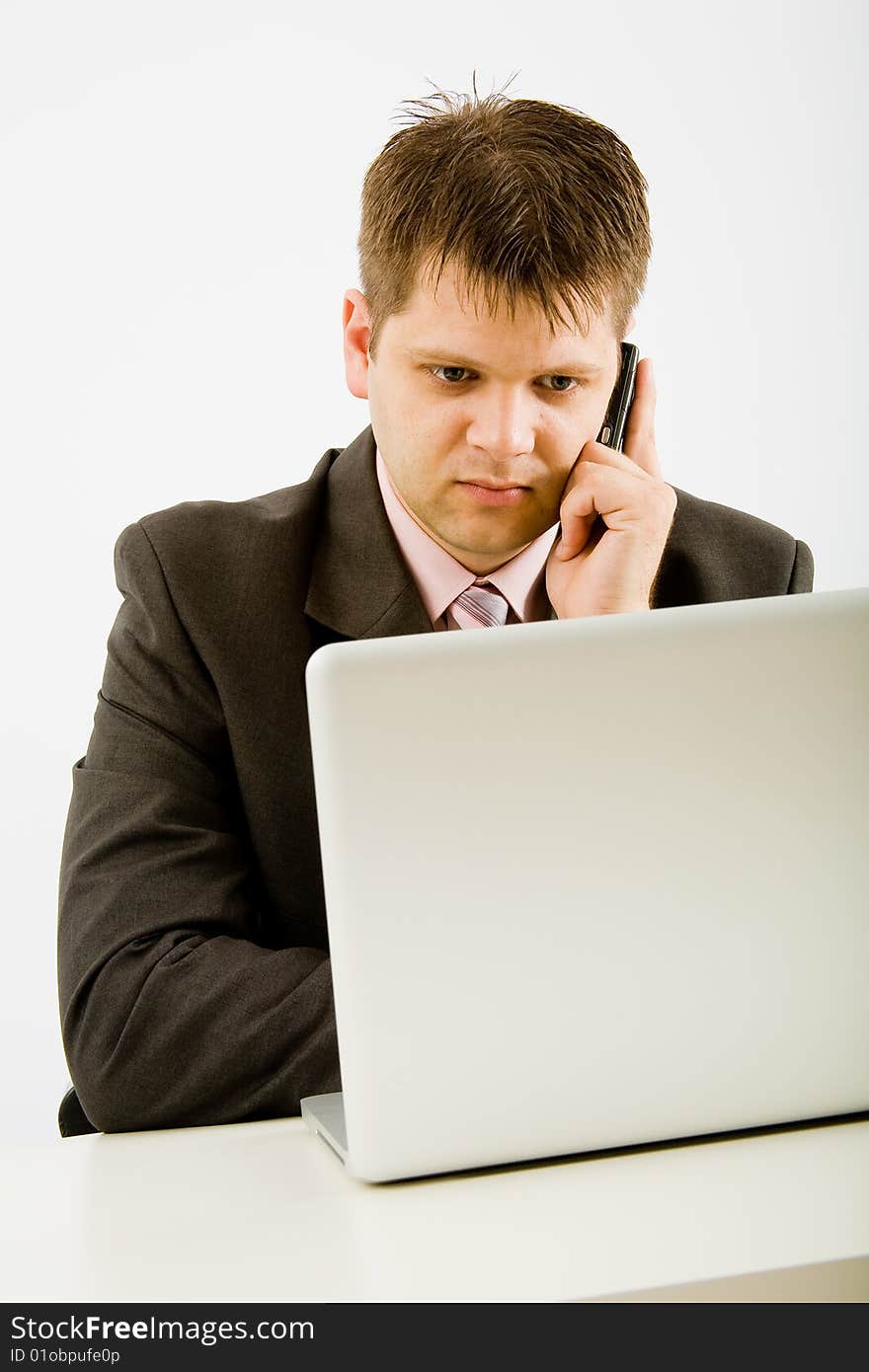 Young businessman working with phone and laptop computer