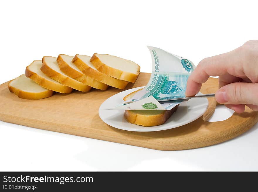 Hand spreads bread with thousand-roube banknote on small plate on chopping board. Hand spreads bread with thousand-roube banknote on small plate on chopping board