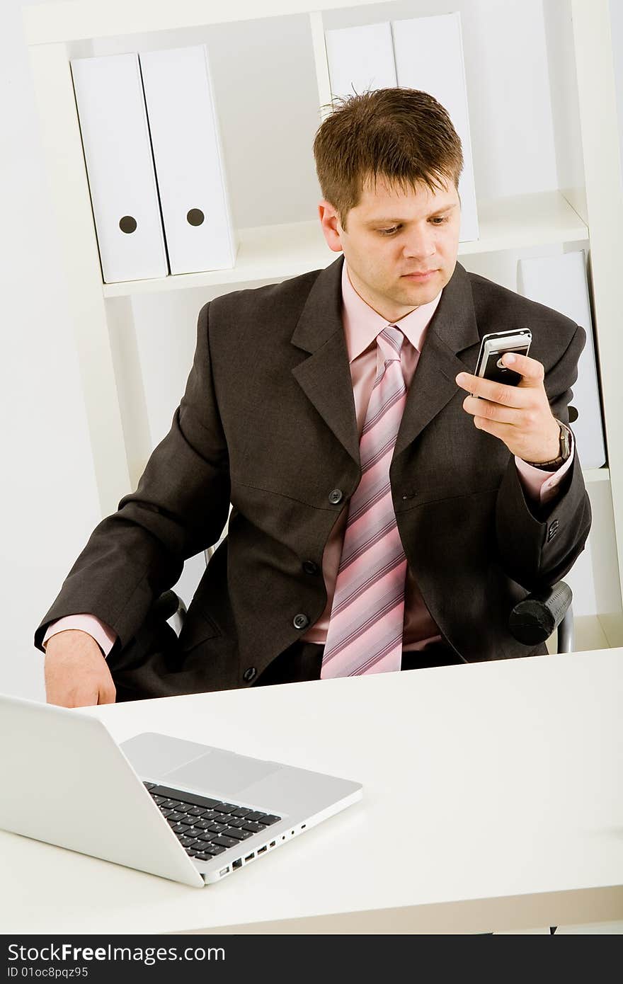 Young businessman working with phone and laptop computer