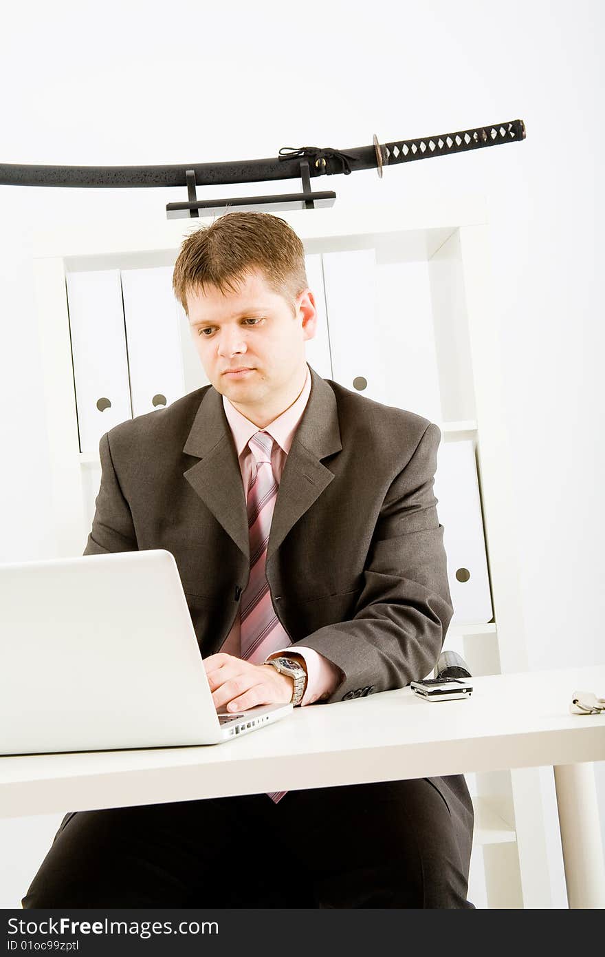 Young businessman working with phone and laptop computer