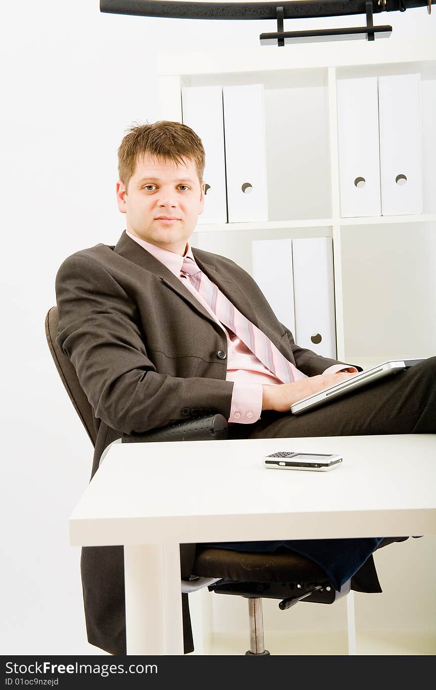 Young businessman working with phone and laptop computer