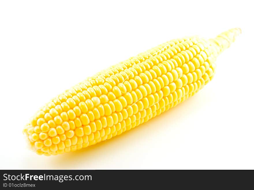 Single whole ear of maize or sweetcorn fully un-wrapped and showing yellow kernels on a white background. Single whole ear of maize or sweetcorn fully un-wrapped and showing yellow kernels on a white background