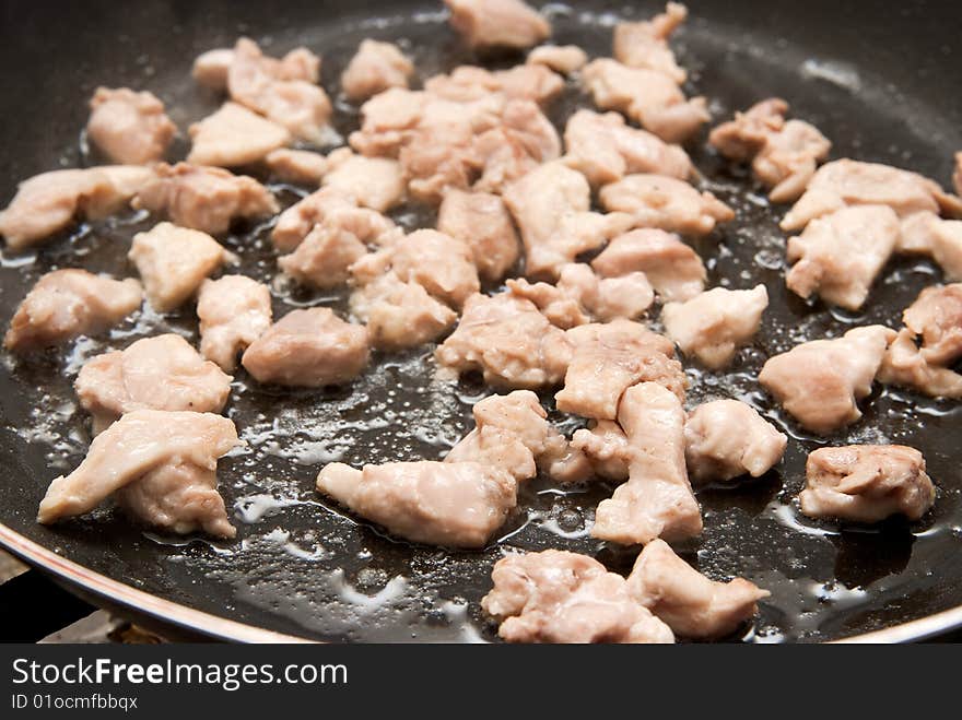 Cooking chicken meat in a pan