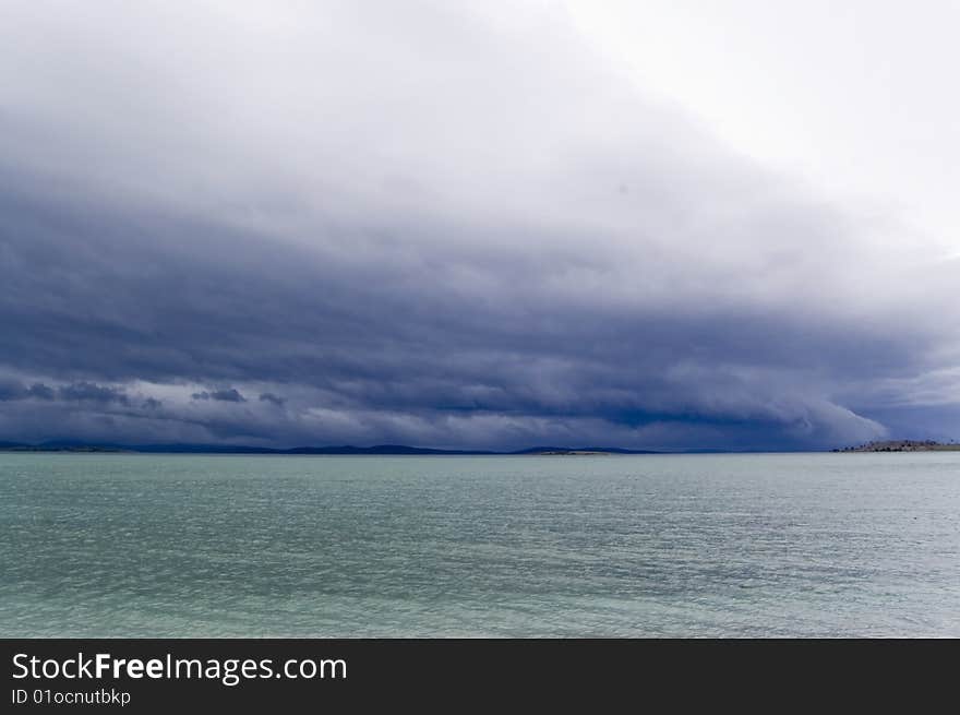 Dark blue storming sky and aquamarine water. Dark blue storming sky and aquamarine water