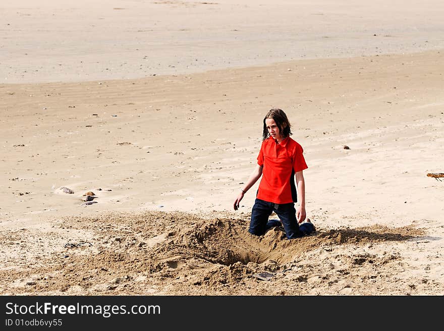 Girl Digging Hole In Sand At The Beach