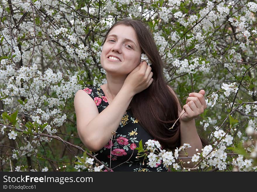 Portrait of young woman in the blossoming garden