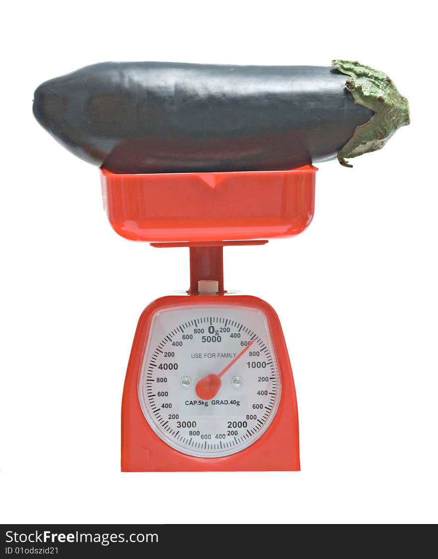 Red kitchen scale weighting eggplant