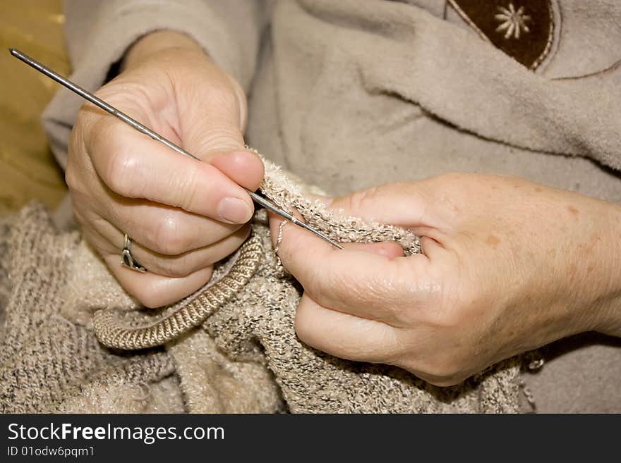 Old lady knitting the pullover.