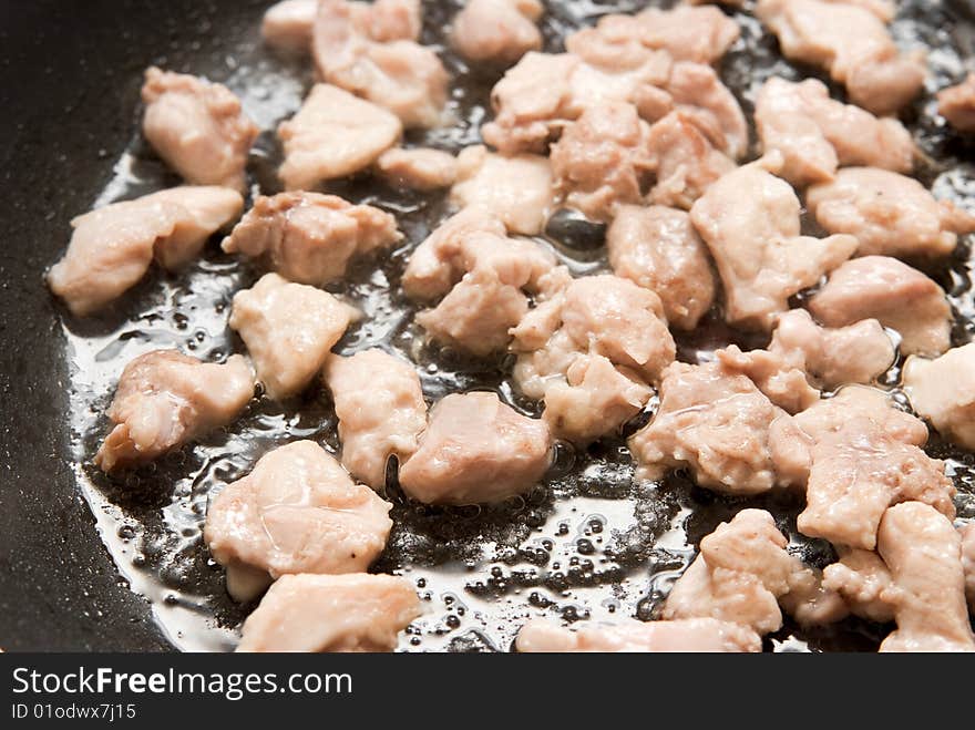 Cooking chicken meat in a pan