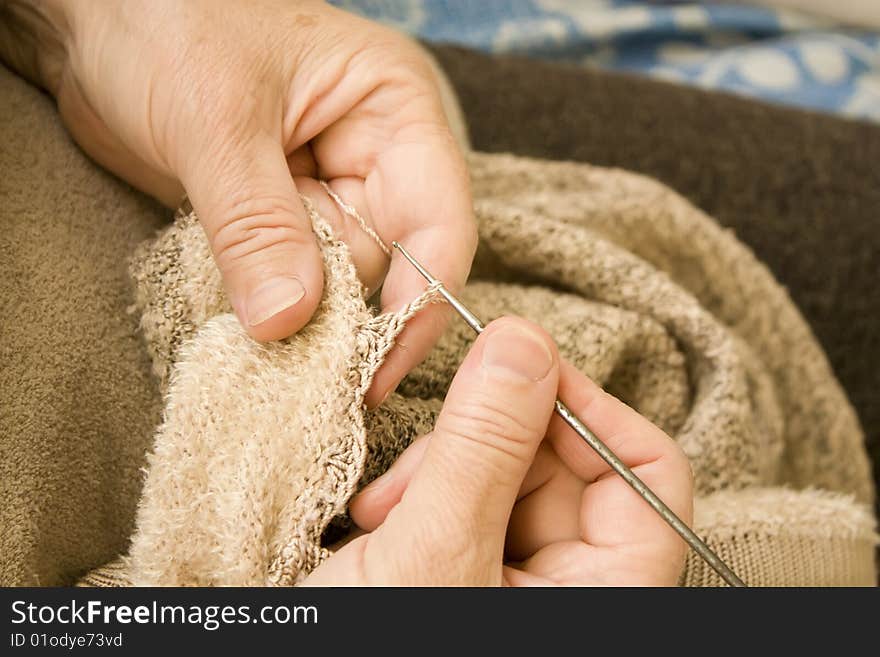 Old women knit a scarf. Old women knit a scarf