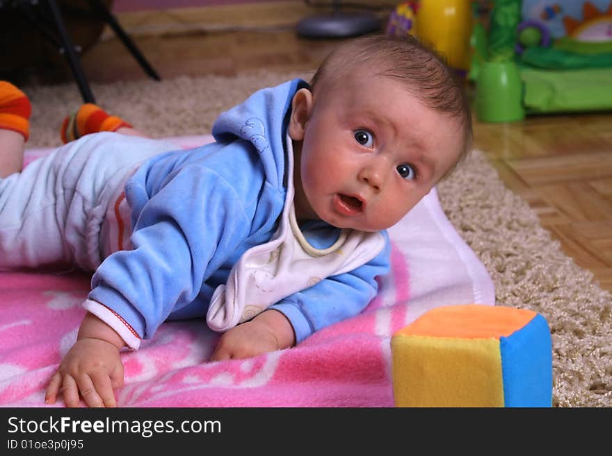 Small young child is playing on the blanket. Small young child is playing on the blanket