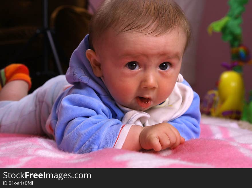 Small young child is playing on the blanket. Small young child is playing on the blanket