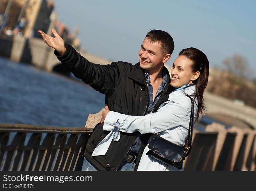 Young couple is laughing on embankment