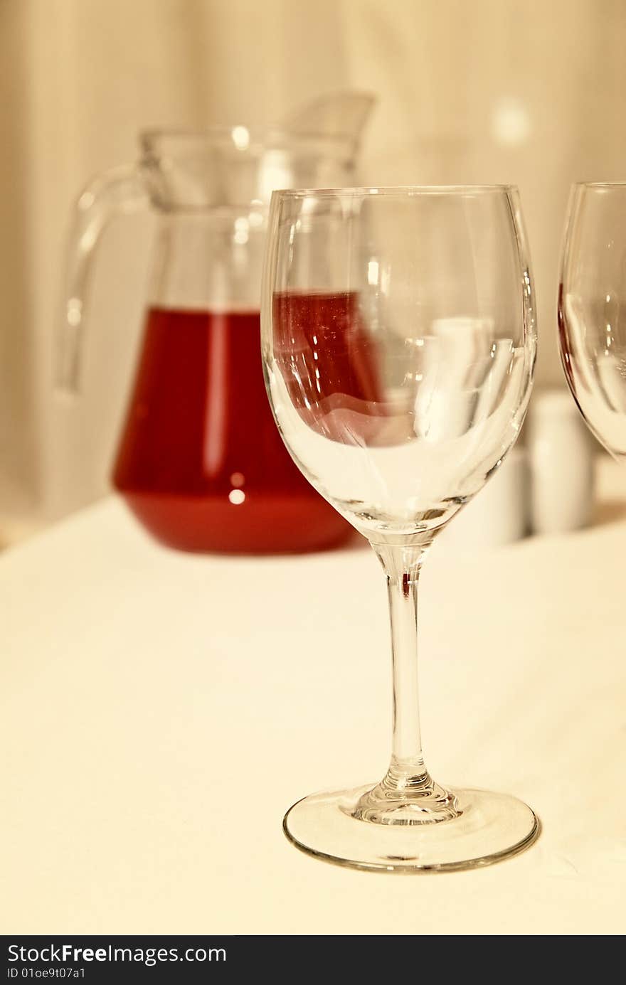 Glass goblet and red beverage on the table