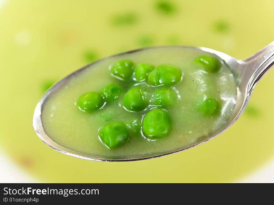 Bowl of pea soup garnished with  cream and crouton.