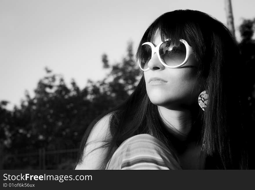 Young modern girl in black-white watch in sun with sunglases