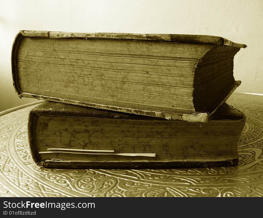 Two old books on a table in sepia