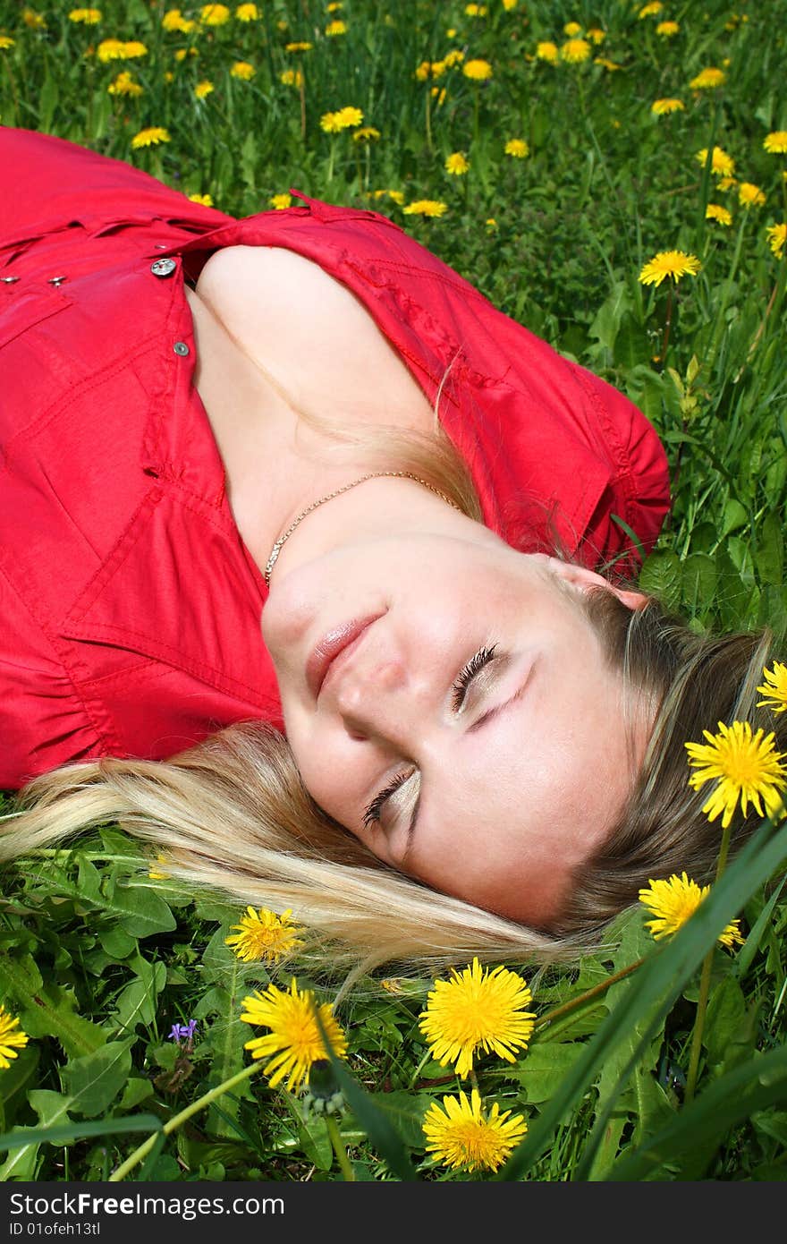 Young girl lying in dandelion meadow