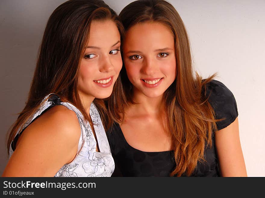 Close-up portrait of two beautiful attractive long-haired smiling girls. Close-up portrait of two beautiful attractive long-haired smiling girls