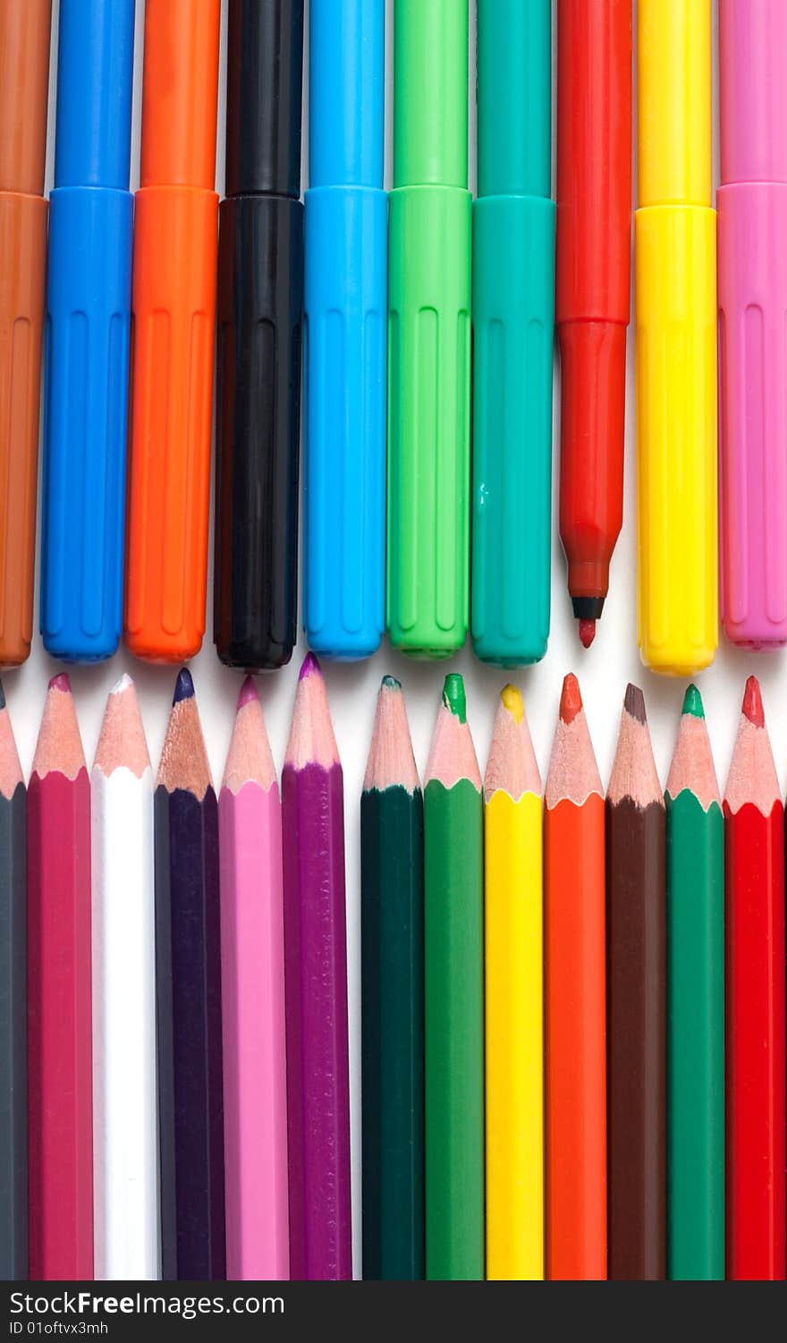 Crayons and soft-tip pens to rest upon white background. Crayons and soft-tip pens to rest upon white background