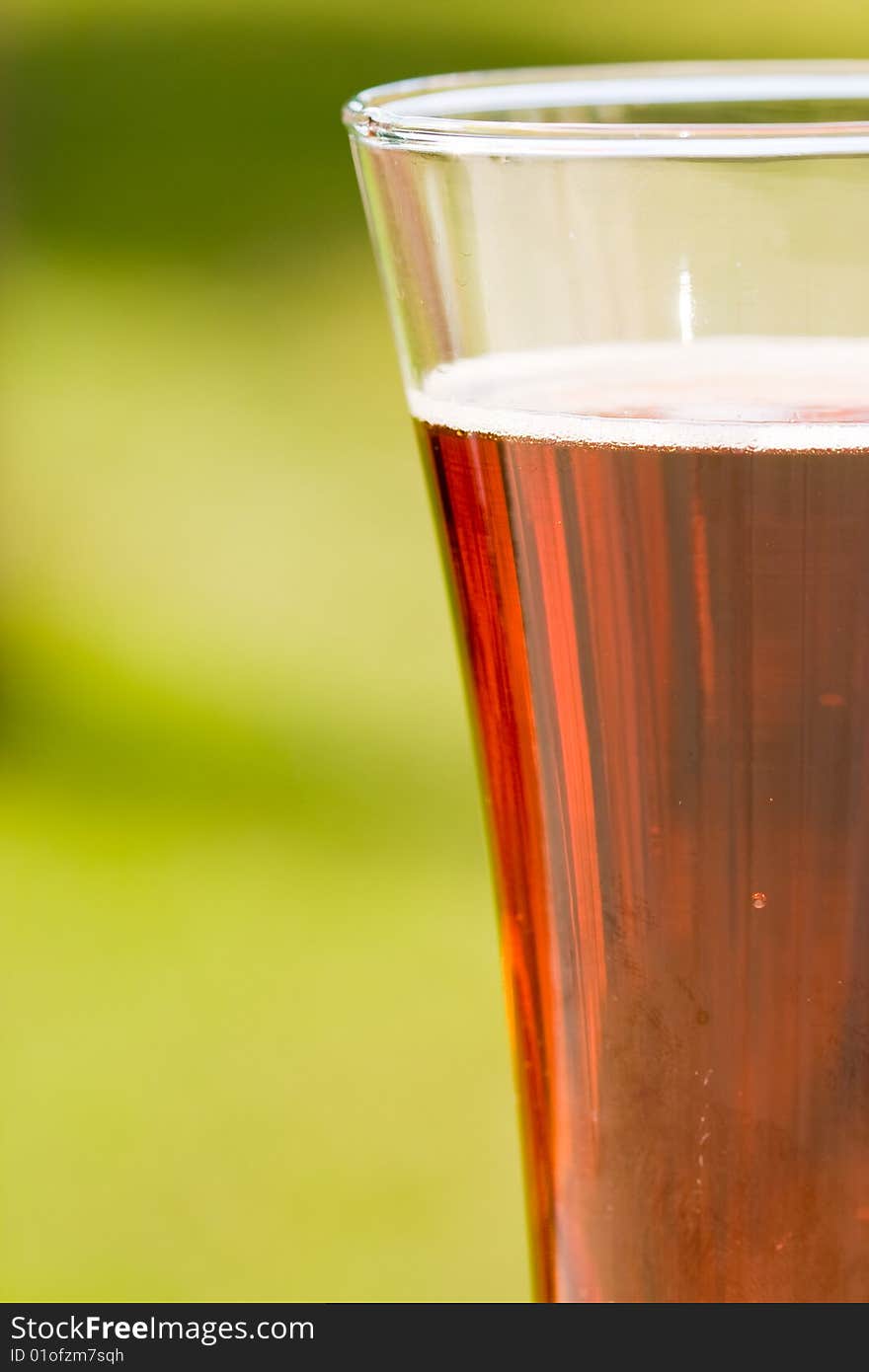 Glass beer on green background