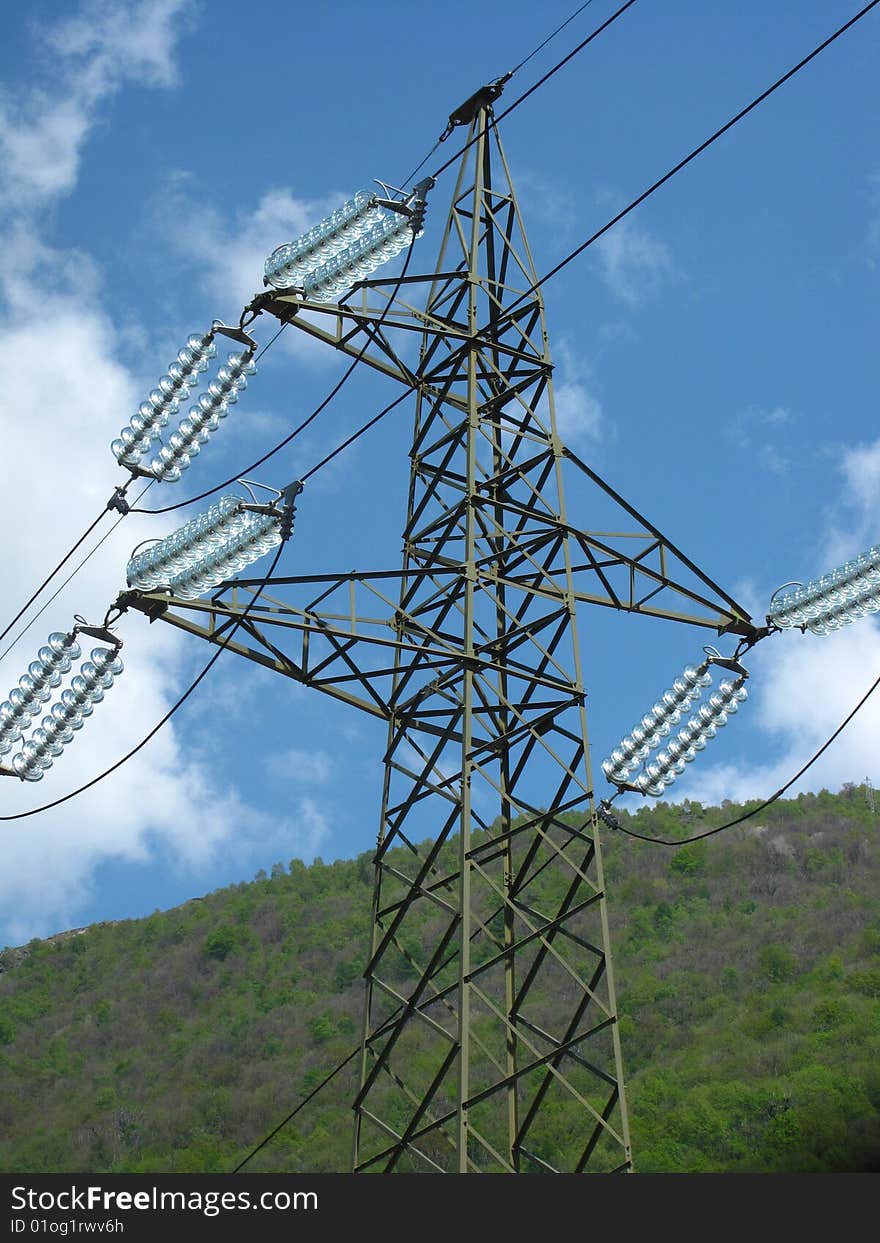 A pylon with a bright blue sky and a beautiful mountain as background. A pylon with a bright blue sky and a beautiful mountain as background