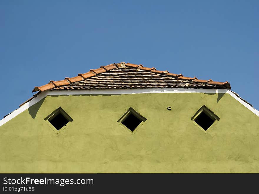 A green old house roof on a sunny day