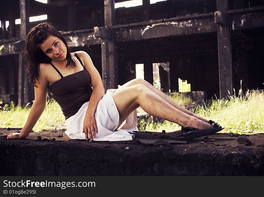 Portrait of an attractive young woman, near old factory ruins